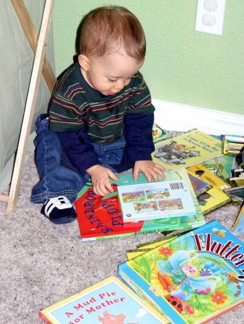 Tyler's favorite place to be -- in the middle of a big pile of books! ~ November 17, 2006