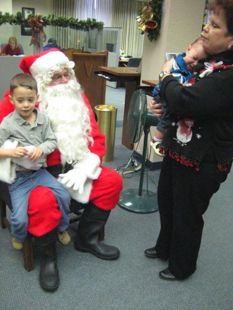 Big brother sitting on Santa's lap, little brother wants nothing to do with it ~ December 24, 2009