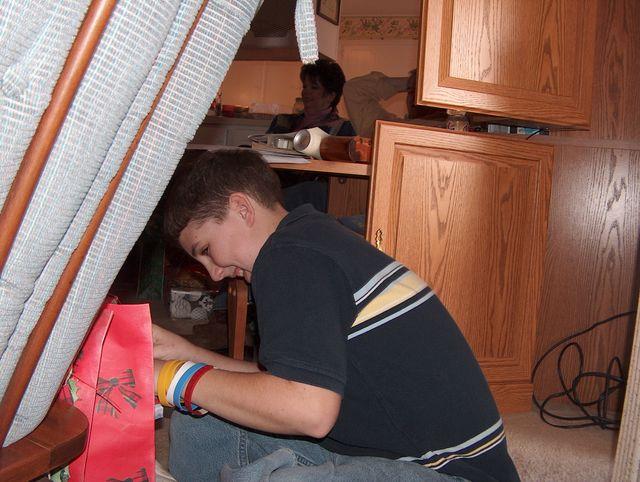 Daniel hiding behind a chair to open his presents