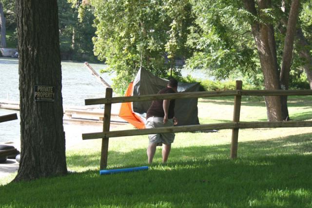 Jake running to save the neighbor's tent from blowing into the river